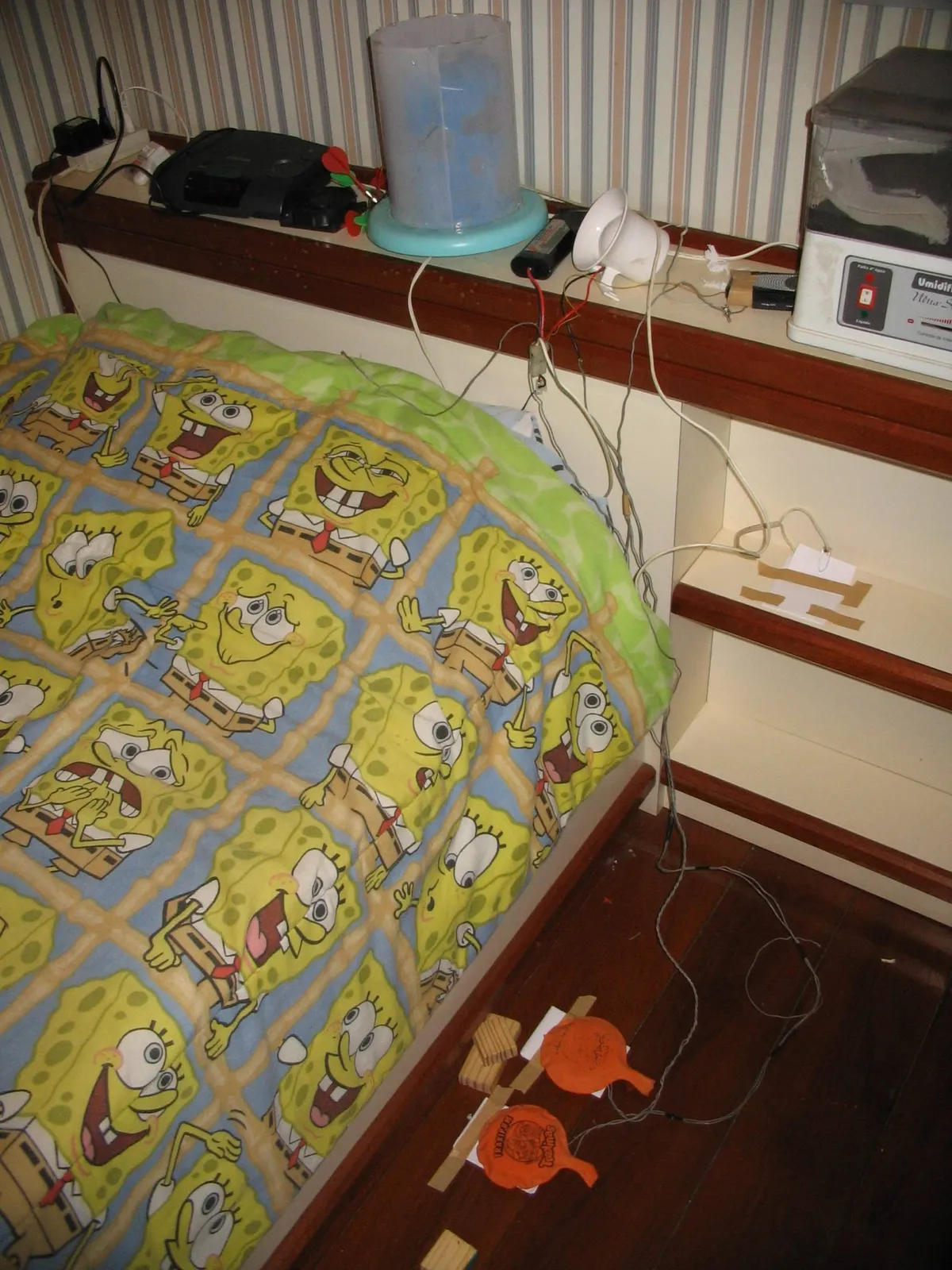 Two wooden foot switches on the bedroom floor, wired to the clock radio and the light.